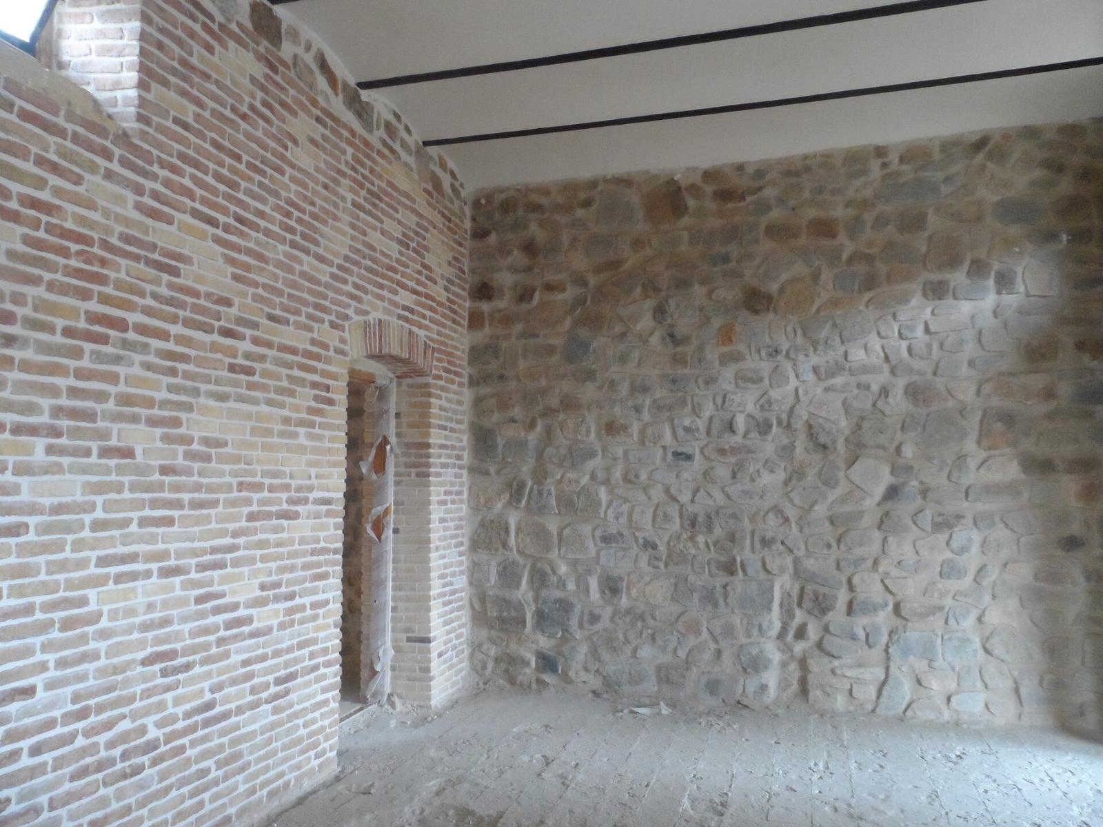 Handbuilt brick and natural stone walls with a steel-framed roof structure