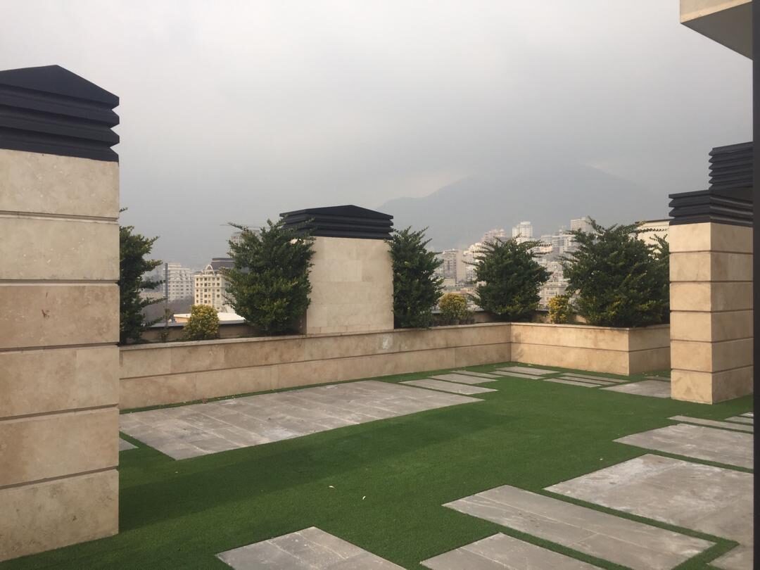 Stone-clad piers, planted troughs and stepping-stone lawn on a city terrace