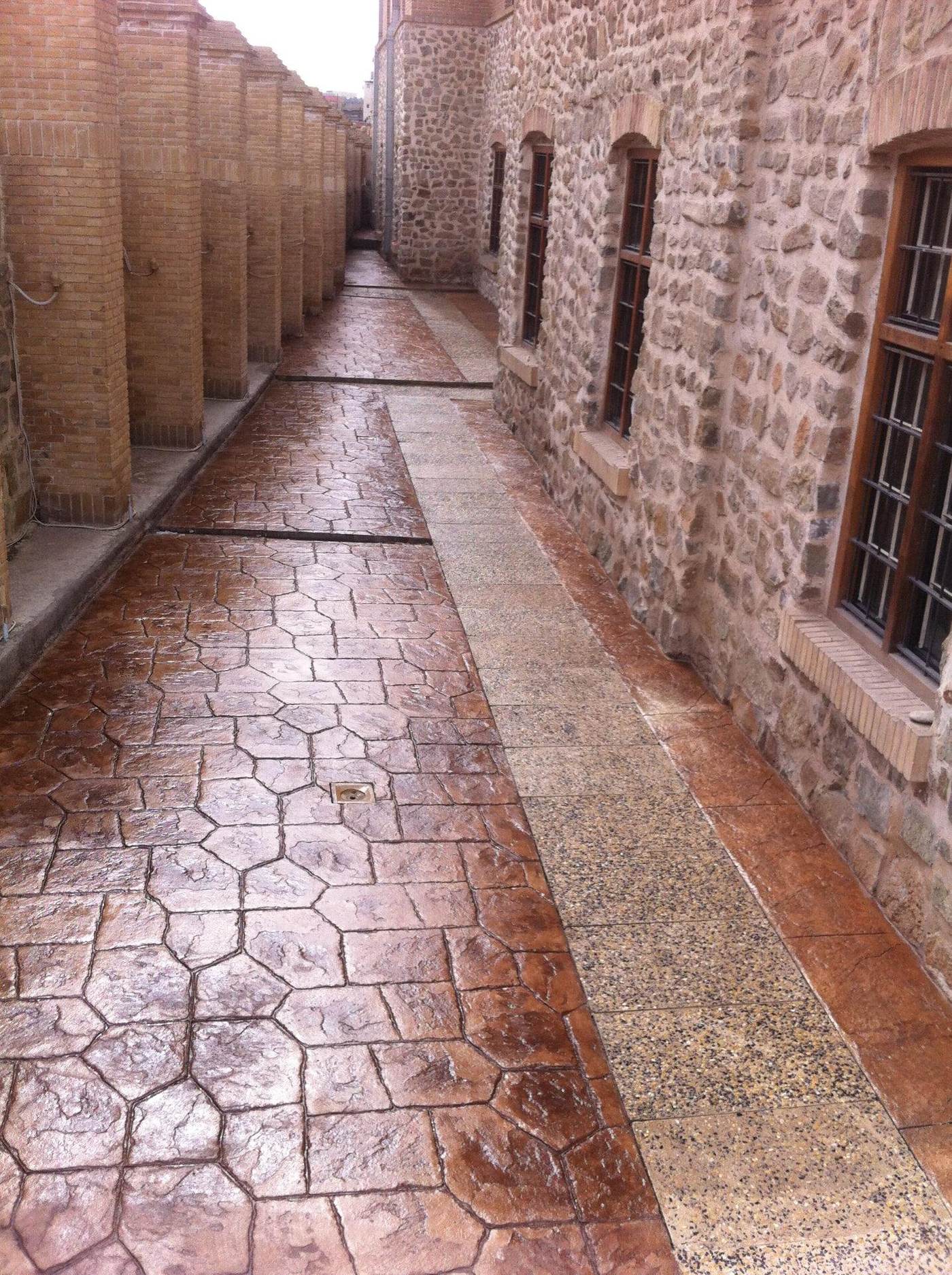 Patterned stone paving and granite banding laid between stone and brick façades