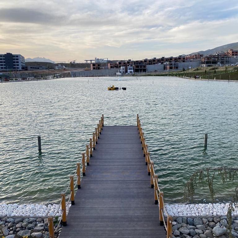 Timber boardwalk reaching out across a calm constructed lake